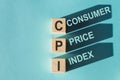 Wooden cubes building word CPI - abbreviation Consumer Price Index on light blue background