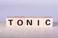wooden cubes building the word Tonic, white background