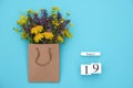 Wooden cubes calendar August 19 and field colorful rustic flowers in craft package on blue background. Greeting card Flat Lay Royalty Free Stock Photo