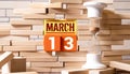 Wooden cubes with figures of the date of the day of the week. Calendar march 13