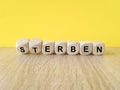 Wooden cubes with the German words \'Sterben\' (die) and \'erben\' (inherit).