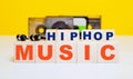 Wooden cubes with the inscription HIP HOP MUSIC on the background of audio cassettes and headphones. Musical concept