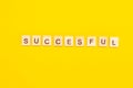 Wooden cubes inscription successful words on yellow background