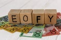 Wooden cubes with letters EOFY on australian dollar banknotes Royalty Free Stock Photo