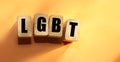 Wooden cubes with letters LGBT on orange, lesbian, gay, bisexual, transgender and social media concept background