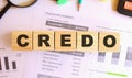 Wooden cubes with letters on the table in the office. Text CREDO.