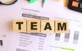 Wooden cubes with letters on the table in the office. Text TEAM