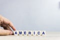 Wooden cubes with letters on a white table. The word is America