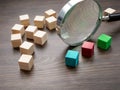 Wooden cubes and magnifying glass. Looking for talent. Recognition of skills abilities.