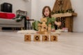 Wooden cubes with the numbers 2022 stand on the floor in a row. Background of a blurred happy girl Royalty Free Stock Photo