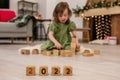 Wooden cubes with the numbers 2022 stand on the floor in a row. Background of a blurred happy girl Royalty Free Stock Photo