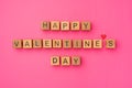 Wooden cubes with the phrase Happy Valentine's Day on an empty colorful pink background. Words of love are made of Royalty Free Stock Photo