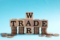 Wooden cubes with phrase Trade war and coins on light blue background Royalty Free Stock Photo