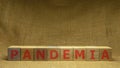 Wooden cubes with red word PANDEMIA on sackloth background. Pandemia and Covid-19 concept