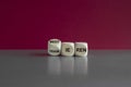 Wooden cubes show the German words meditieren and traimieren. Beautiful red background, grey table.
