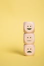 Wooden Cubes smilies faces symbols on yellow , Customer experience rating