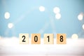 Wooden cubes with 2018 on table over blur bokeh light background with copy space