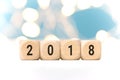 Wooden cubes with 2018 on table over blur bokeh light background with copy space