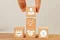 Wooden cubes with teamwork, hand shake, money, bulb and businessman icons. Concept of business strategy and action plan Royalty Free Stock Photo