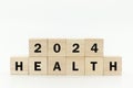 Wooden cubes 2024 with text HEALTH on white background