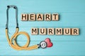 Wooden cubes with text Heart Murmur and stethoscope