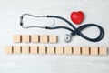 Wooden cubes with text Heart Palpitations and stethoscope on light background