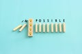 Wooden cubes with the text impossible, stopping the domino effect. success and challenge concept Royalty Free Stock Photo