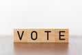 Wooden cubes with vote written against white background