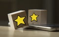 wooden cubes which depict 2 stars lying on a laptop