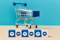 Wooden cubes with wifi, truck signs. Shopping cart on blurred background. Online supermarket. Delivery service. E-store