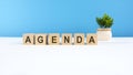 the word AGENDA is written on wooden cubes on a light blue background Royalty Free Stock Photo
