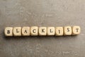 Wooden cubes with word Blacklist on grey background, flat lay