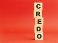 Wooden cubes with word CREDO. Wooden cubes on a red background. Free space on the left