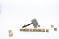 The wooden cubes with the word DOMINANCE and the weapon around against white background. The medieval hammer on a wooden cube