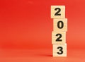 Wooden cubes with word 2023. Wooden cubes on a red background. Free space on the left.