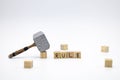The wooden cubes with the word RULE and the weapon around against white background. The medieval hammer on a wooden cube