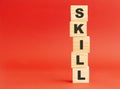 Wooden cubes with word SKILL. Wooden cubes on a red background. Free space on the left