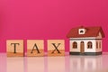 Wooden cubes with word TAX and house model Royalty Free Stock Photo