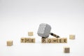 The wooden cubes with the words THE POWER and the weapon around against white background. The medieval hammer on a wooden cube