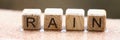 Wooden cubes with words rain lying on wet windowsill closeup