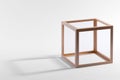 Wooden cubic frame with a shadow on white