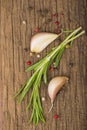 wooden culinary background with garlic, rosemary, bay leaves, pepper and some cloves pictured on it Royalty Free Stock Photo