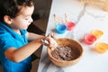 A wooden cup with a dough in the hands of a child Royalty Free Stock Photo