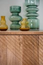Wooden cupboard with decorative vases from transparent glass of green and yellow color