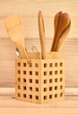 Wooden cutlery, bamboo Spatulas and spoons in wooden basket on beige kitchen countertop. Beige kitchen interior with wooden spoons Royalty Free Stock Photo