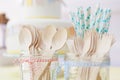 Wooden cutlery and paper straws in jam jars tied with kitchen twine