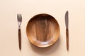 Wooden Cutlery: plate, fork, knife on a baige table. Table setting. Top view. Horizontal orientation