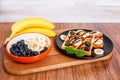 On a wooden cutting board - banana and a plate with Belgian wafe