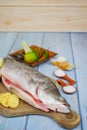 Wooden cutting board   with baramundi, salt, msg,ginger,garlic,onion,key lime, chilies,  and lemongrass Royalty Free Stock Photo