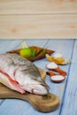 Wooden cutting board with baramundi, salt, msg,ginger,garlic,onion,key lime, chilies, and lemongrass Royalty Free Stock Photo